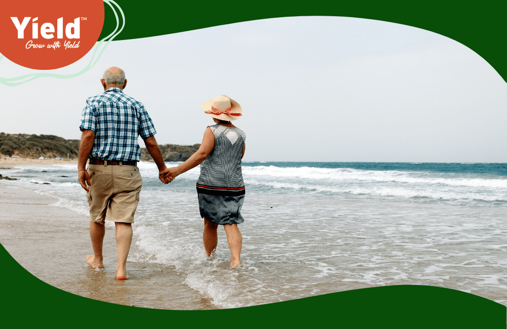Senior couple walking along beach, holding hands