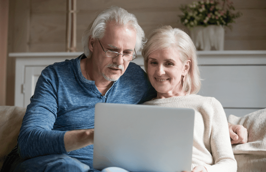 A retired couple working on a laptop