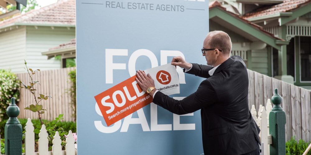 Sold sign in front of an Australian house, representing strategic tax planning through the sale of a property asset