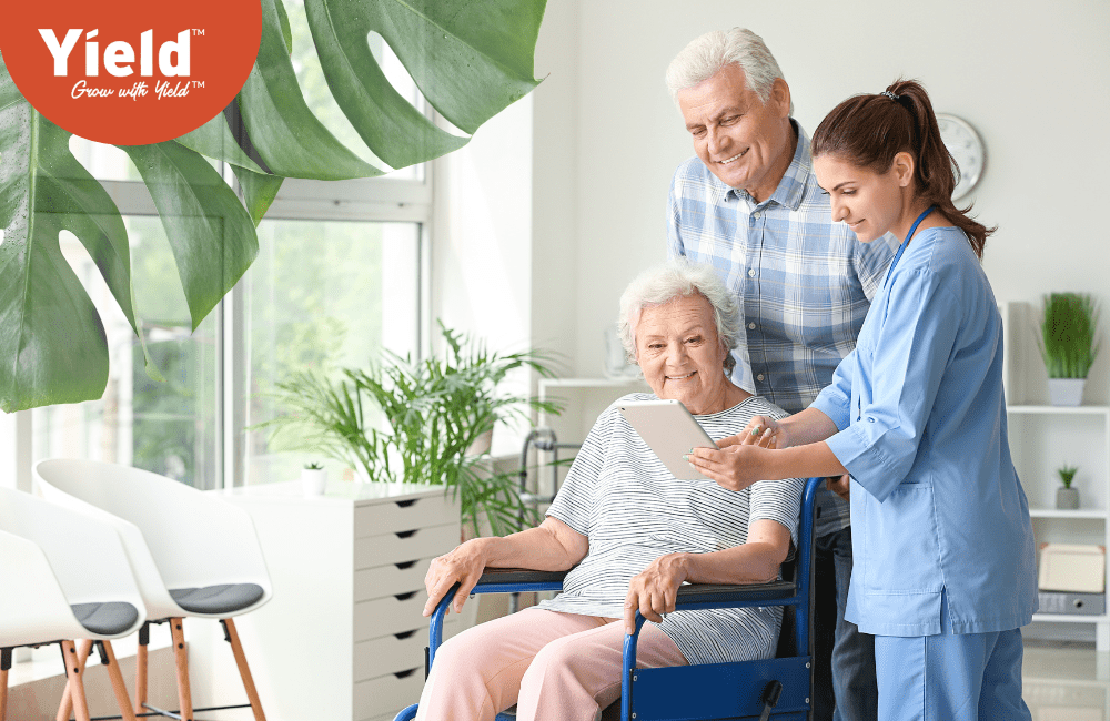 Elderly couple and an aged care nurse in a brightly lit aged care room, engaging in positive interaction. Depicts a secure aged care plan and lifestyle.