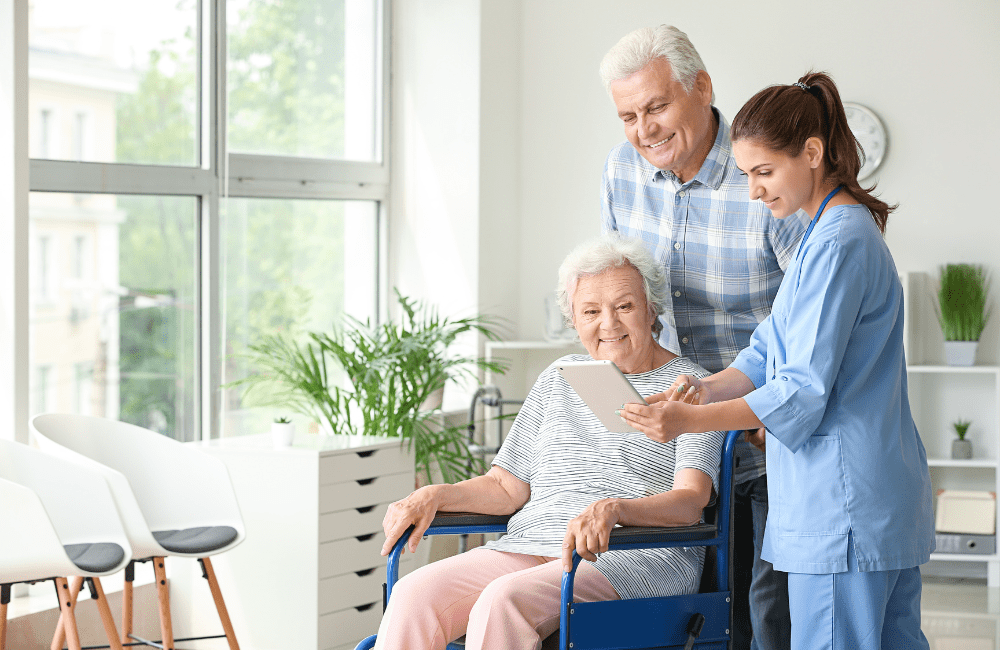 Elderly couple and an aged care nurse in a brightly lit aged care room, engaging in positive interaction. Depicts a secure aged care plan and lifestyle.